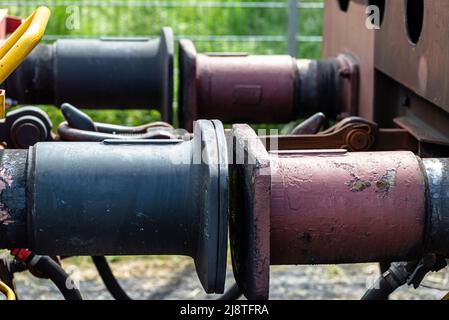 Kettenkupplung verbindet Güterwagen, große Wagenpuffer sichtbar. Stockfoto
