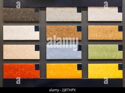 Linoleum-farbige Proben an der Wand in Baustofflagern. Katalog mit Bodenmustern. Stockfoto