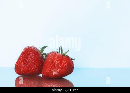 Erdbeeren isoliert. Erdbeere mit Blatt isolieren. Zwei ganze Erdbeeren auf Weiß. Seitenansicht. Natürlich Stockfoto