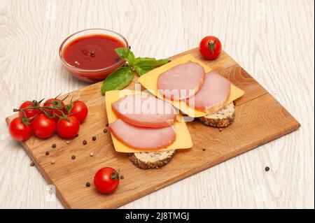 Sandwiches mit Käse und Schinken auf einem Holzbrett Stockfoto