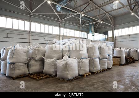 Riesige Plastiktüten mit Produkten auf Paletten in der Recyclingfabrik Stockfoto