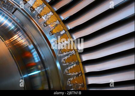 Welle und Rotorblätter einer leistungsstarken Dampfturbine. Elemente zur Befestigung der Rotorblätter im Wellensockel. Stockfoto