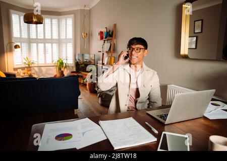 Junger asiatischer Mann, der am Handy chattet Stockfoto