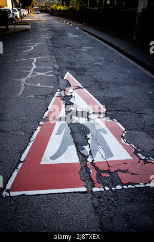 Achtung Kinder, Beschädigte Straßenmarkierung Auf Beschädigtem Asphalt. Speed 30, Kindergarten, Tagespflegezentrum , Schule, Rehabilitationsrückstand, Straßenwartung Stockfoto