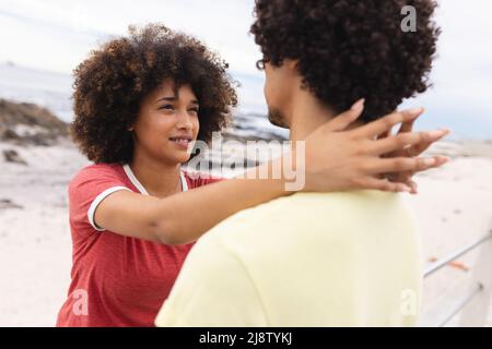 Liebevolle junge afroamerikanische Frau, die auf afro Freund schaut, während sie Freizeit zusammen verbringt Stockfoto