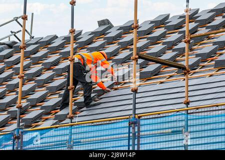 Arbeiter, der ein Dach auf ein neues Haus kachelt, Irvine, Ayrshire, Schottland, Großbritannien Stockfoto