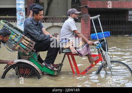 Sylhet, Mexiko-Stadt, Bangladesch. 17.. Mai 2022. Die Menschen gehen mit der Rikscha auf der versunkenen Straße ans Ziel. Viele Straßen auf Sylhet entlang des Flusses wurden aufgrund der anhaltenden starken Regenfälle für mehrere Tage eingetaucht. Das Wasser aller Flüsse der Sylhet-Division, einschließlich des Surma-Flusses von Sylhet, fließt über die Gefahrenzone. Am 17. Mai 2022 in Sylhet, Bangladesch. (Bild: © MD Rafayat Haque Khan/eyepix via ZUMA Press Wire) Stockfoto