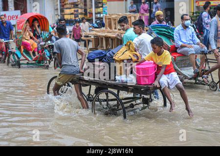 Sylhet, Mexiko-Stadt, Bangladesch. 17.. Mai 2022. Die Menschen gehen mit der Rikscha auf der versunkenen Straße ans Ziel. Viele Straßen auf Sylhet entlang des Flusses wurden aufgrund der anhaltenden starken Regenfälle für mehrere Tage eingetaucht. Das Wasser aller Flüsse der Sylhet-Division, einschließlich des Surma-Flusses von Sylhet, fließt über die Gefahrenzone. Am 17. Mai 2022 in Sylhet, Bangladesch. (Bild: © MD Rafayat Haque Khan/eyepix via ZUMA Press Wire) Stockfoto