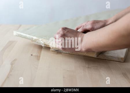 Auspacken eines Möbelbretts mit einem Messer. Auspacken eines Holzbretts. Stockfoto