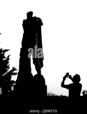 Silhouette einer Statue in der römischen Stadt Italica in der Nähe von Sevilla, die fotografiert wird. Stockfoto