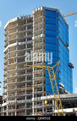 Bau und Verglasung eines mehrstöckigen Wohngebäudes mit Winden und Hängebühnen. Stockfoto