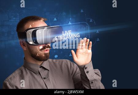 Geschäftsmann schaut durch Virtual Reality Brille, Social-Media-Konzept Stockfoto