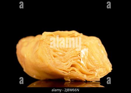Eine Scheibe süßer Honig-Baklava, Nahaufnahme, isoliert auf schwarzem Hintergrund. Stockfoto