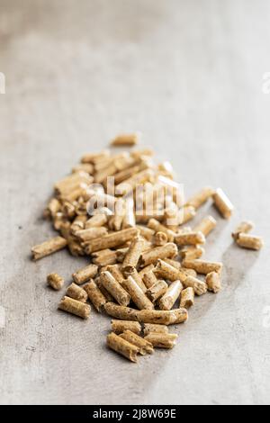 Holzpellets, Biokraftstoff auf einem Holztisch. Ökologischer Brennstoff aus Biomasse. Erneuerbare Energiequellen. Stockfoto