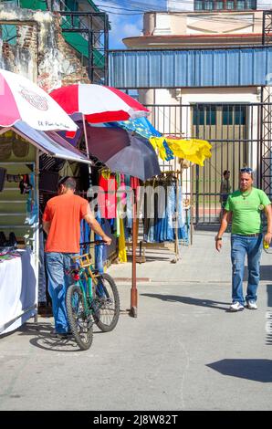 Ein Mann mit einem Fahrrad stöbert in den diversen Automaten des Plaza Polo durch die Ware Stockfoto