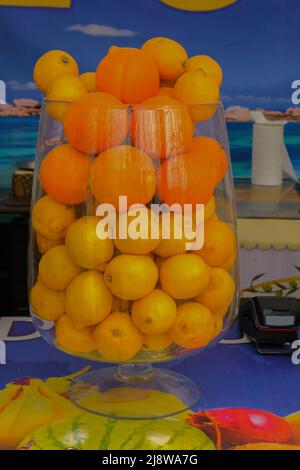 Obstpunsch in einer großen Glasschüssel. Trinken Sie mit einer Vielzahl von Früchten aus nächster Nähe. Oranger alkoholischer Cocktail. Stockfoto