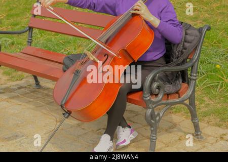 Junges Mädchen spielen Cello, close-up. Musikkonzert ? Straßenmusik. Mädchen spielt das Cello Stockfoto