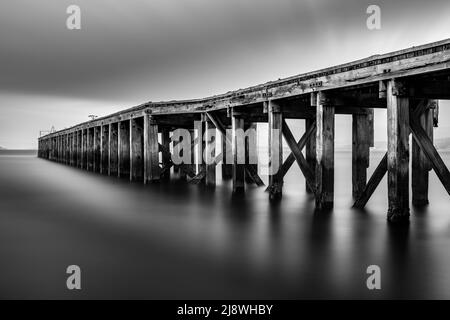 Langzeitbelichtung Monochrome Aufnahme des Lamonts Pier in Newark, Port Glasgow, Schottland, das historisch und verrottet ist. Stockfoto