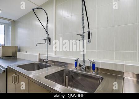 Ellenbogen Seife und antiseptischen Spender oder Desinfektionsmittel Wand zur Händedesinfektion und Wasserhahn Waschbecken mit Wasserhahn Bad oder Klinik montiert Stockfoto