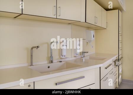 Ellenbogen Seife und antiseptischen Spender oder Desinfektionsmittel Wand zur Händedesinfektion und Wasserhahn Waschbecken mit Wasserhahn Bad oder Klinik montiert Stockfoto