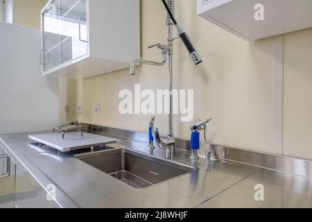 Ellenbogen Seife und antiseptischen Spender oder Desinfektionsmittel Wand zur Händedesinfektion und Wasserhahn Waschbecken mit Wasserhahn Bad oder Klinik montiert Stockfoto