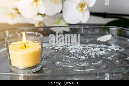 Foto einer Kerze mit Regen, Wassertropfen, die das Feuer löschen, Wasserspritzer Stockfoto