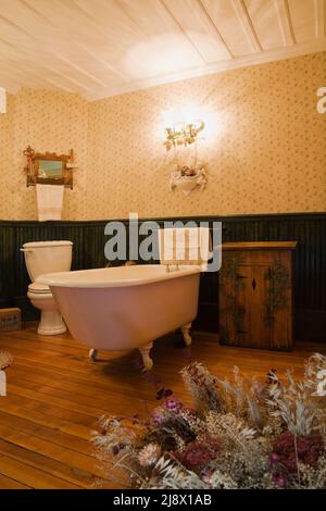 Freistehende Kralle Fuß Roll-Top-Badewanne, Holzschrank im Bad im alten 1831 Canadiana Steinbruch Haus. Stockfoto