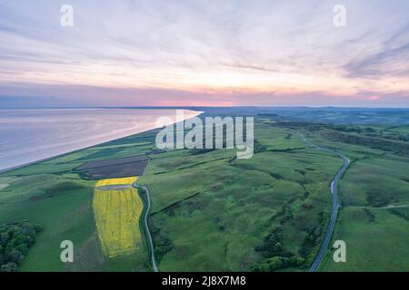 Sonnenuntergang über Rapsfeld und Ackerland von einer Drohne, Dorset, England Stockfoto