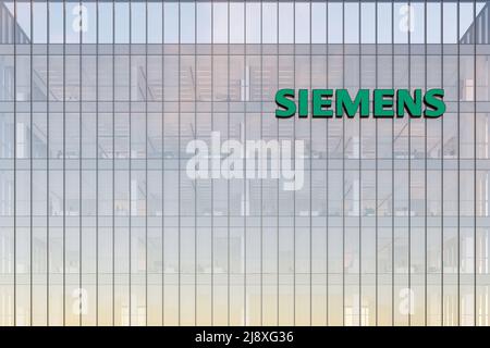 München, Deutschland. 2.Mai 2022. Nur zur redaktionellen Verwendung, 3D CGI. Siemens Signage-Logo auf dem Glasgebäude. Workplace Automation Company Office Headquart Stockfoto