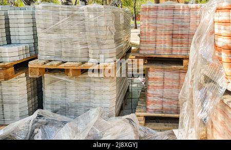 Aus nächster Nähe werden die neuen Pflasterplatten ordentlich auf Paletten gestapelt. Reparatur von Gehwegen und Austausch von Pflasterplatten. Wiederaufbau der Stadt Stockfoto