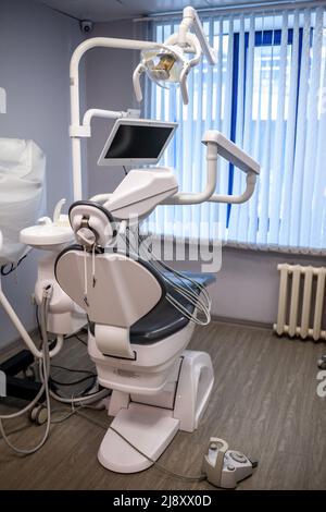 Dental Innenbüro mit moderner Ausstattung. Moderne Zahnarztpraxis. Zahnarztstuhl und anderes Zubehör von Zahnärzten in blau, Sanitäter Licht verwendet Stockfoto