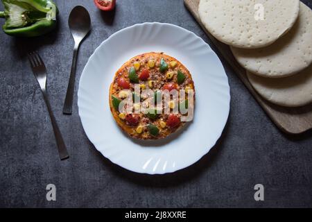 Margherita Pizza auf weißem Teller auf dunklem Hintergrund. Draufsicht. Stockfoto