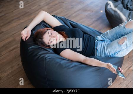 Kaukasische junge Frau, die auf einem Sitzsack schläft Stockfoto