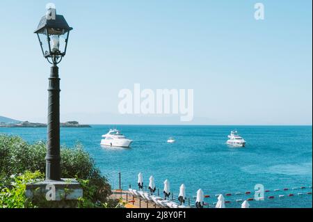 Aufnahme des Meeres mit Luxusbooten, die die türkisfarbene Mittelmeerküste genießen. Stockfoto