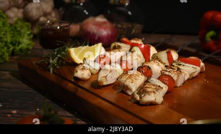 Köstliche Grillspieße Hähnchen Kebabs mit Gemüse auf Holzplatte Stockfoto