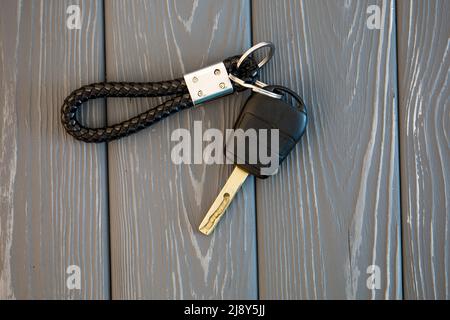 Autoschlüssel mit Schlüsselanhänger auf den Brettern Stockfoto
