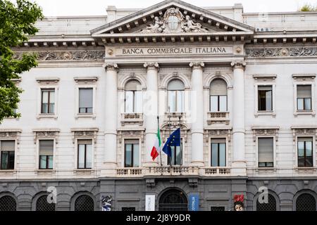 Banca Commerciale Italiana (BCI-Palast) in Mailand, auf der Piazza della Scala. Flaggen der italienischen und der Europäischen Union auf dem historischen Gebäude. Stockfoto