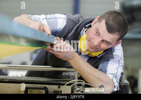 kaukasischer Arbeiter, der Fabrikmaschinen vorbereitet Stockfoto