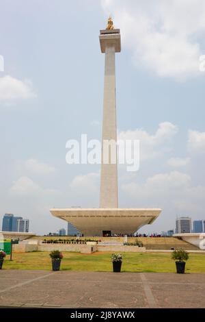 Vertikales Bild des Jakarta National Monument an einem sonnigen Tag mit blauem Himmel und hellen Wolken im Hintergrund Stockfoto