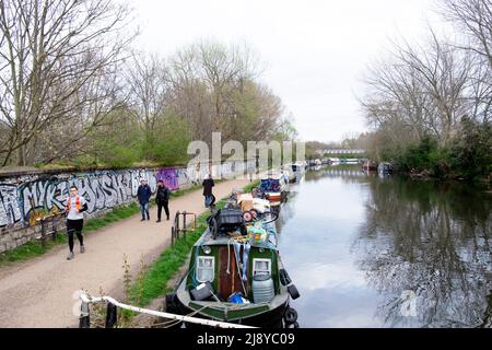 Menschen auf dem Fahrrad-Fußgänger-Pfad und den Schmalbooten entlang des Flusses Lea in Clapton im Frühjahr London E5 England Großbritannien KATHY DEWITT Stockfoto