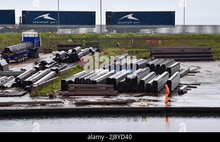 Brighton UK 19. May 2022 - Hafenarbeiter im Regen auf einem Stahllager in Shoreham Port, Sussex nach einer Nacht von Donner und Gewittern an der Südküste : Credit Simon Dack / Alamy Live News Stockfoto