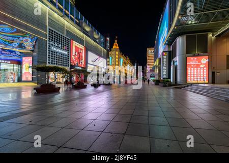 Die Nanjing Road in Shanghai ist die verkehrsreichste Handelsstraße in ganz China, aber sie ist in der Nacht, bevor die Stadt Shanghai die Sperre einleitet, unheimlich leer. Stockfoto