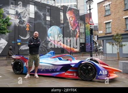 Der Graffiti-Künstler Mr. Cenz aus East London posiert neben einem Formel-E-Auto, das er während seiner Enthüllung im New Inn Yard, Shoreditch, East London, besprüht hat, um die Rückkehr des London E-Prix 2022 am 30. Und 31. Juli zu markieren, und die Tickets werden heute verkauft. Bilddatum: Donnerstag, 19. Mai 2022. Stockfoto