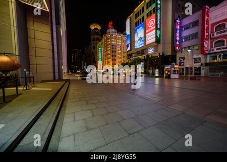 Die Nanjing Road in Shanghai ist die verkehrsreichste Handelsstraße in ganz China, aber sie ist in der Nacht, bevor die Stadt Shanghai die Sperre einleitet, unheimlich leer. Stockfoto