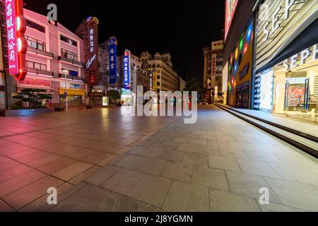 Die Nanjing Road in Shanghai ist die verkehrsreichste Handelsstraße in ganz China, aber sie ist in der Nacht, bevor die Stadt Shanghai die Sperre einleitet, unheimlich leer. Stockfoto