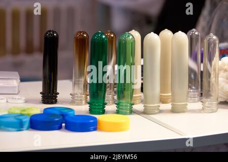 Farbige Plastikflasche PET Preforms und Kappen. Kolben für Blasformen, Abfüllen und Etikettieren, Flaschenherstellung. Stockfoto