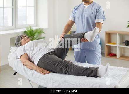 Chiropraktiker, Osteopathin oder Physiotherapeut untersuchen Bein und Knie einer älteren Frau Stockfoto