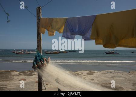 Wäscherei- und Fischernetz im Hintergrund von Fischerbooten und Indischem Ozean, fotografiert am Malabero (Malabro) Strand in Bengkulu, Indonesien. Stockfoto