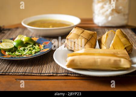 Reiskuchen (Ketupat) wird gekocht Reis verpackt in einem diamantförmigen Behälter aus geflochtenem Palmblatt-Beutel für die Moslem-Geburtstagsfest. Eid Mubarak Konzept. Indo Stockfoto