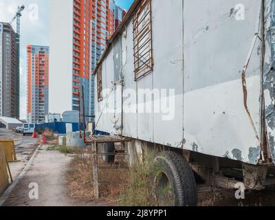 Eine Baustelle mit einem Auflieger im Vordergrund und neue Hochhäuser im Hintergrund in Kiew, Ukraine. Neubau im Bezirk Stockfoto